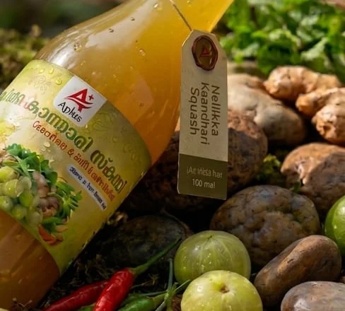 Nellikka Kaandhari Squash bottle resting among ginger, gooseberries and chillies